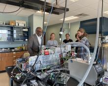 Brett Palm explains the CIMS instrument while and NCAR Director Everette Joseph and NSF Atmospheric and Geospace Sciences (AGS) division director Anne Johansen look on.